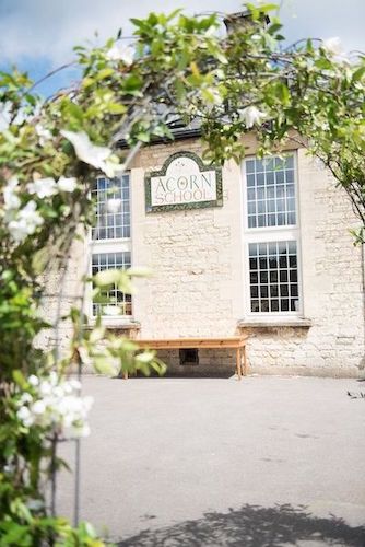 Stone exterior and entrance sign at The Acorn School in Nailsworth