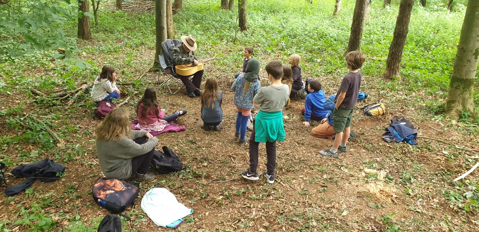 Acorn School pupils and a teacher learning together in woodland