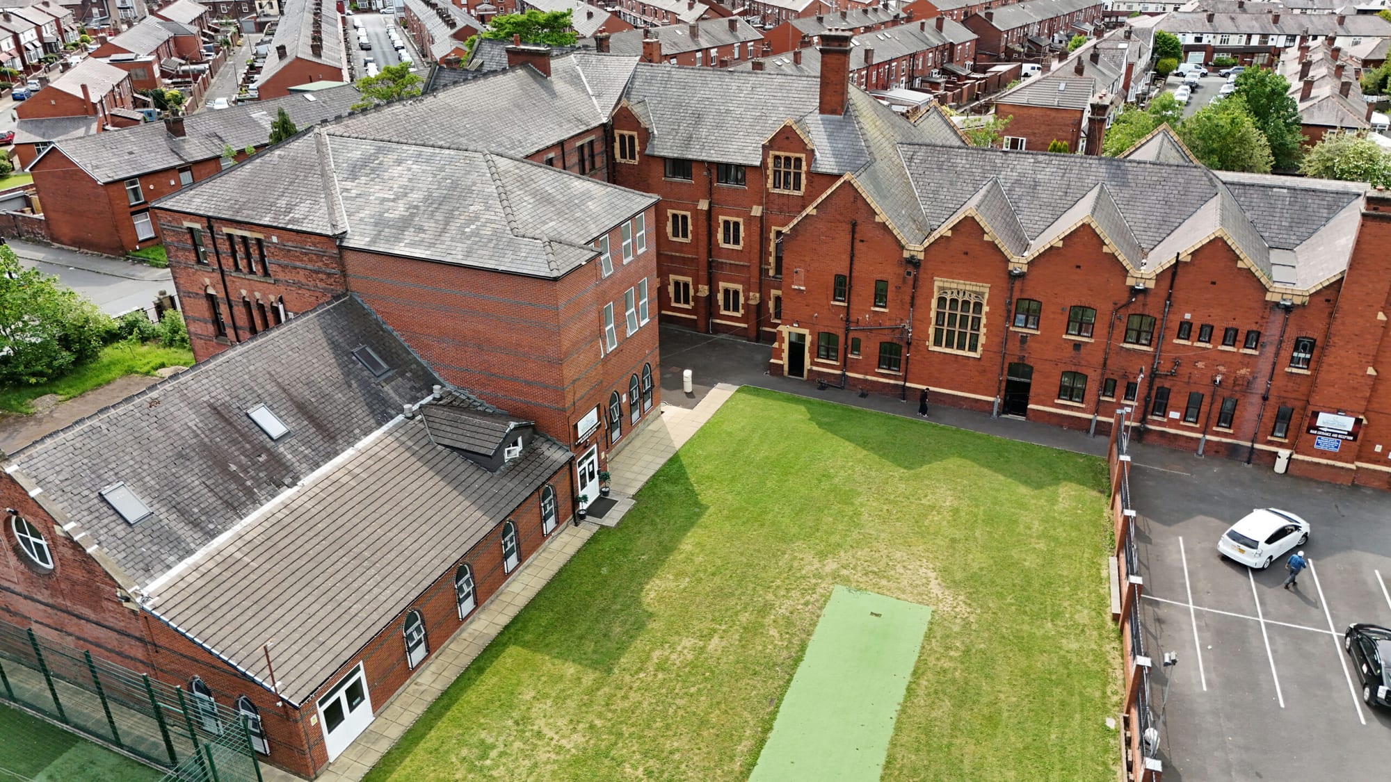 Aerial exterior view of Al Jamiah Al Islamiyyah's red-brick campus in Bolton