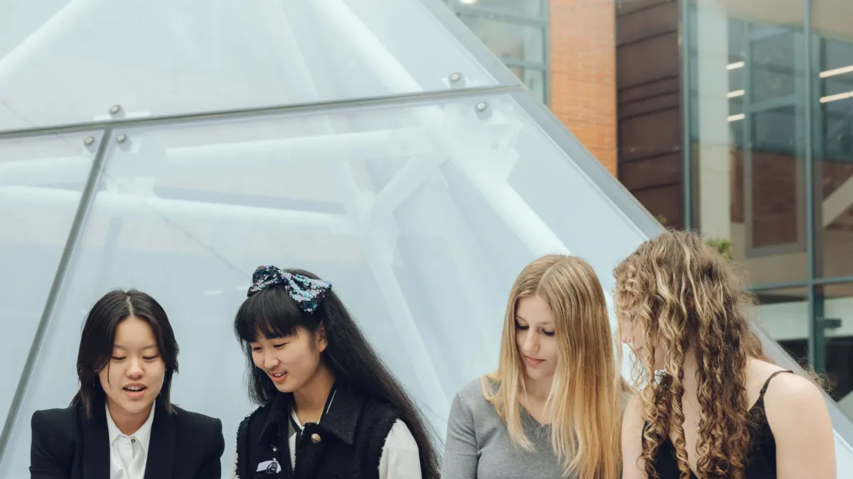 Four people reading outside a building