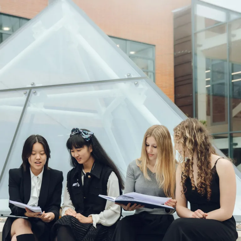 Four people reading outside a building