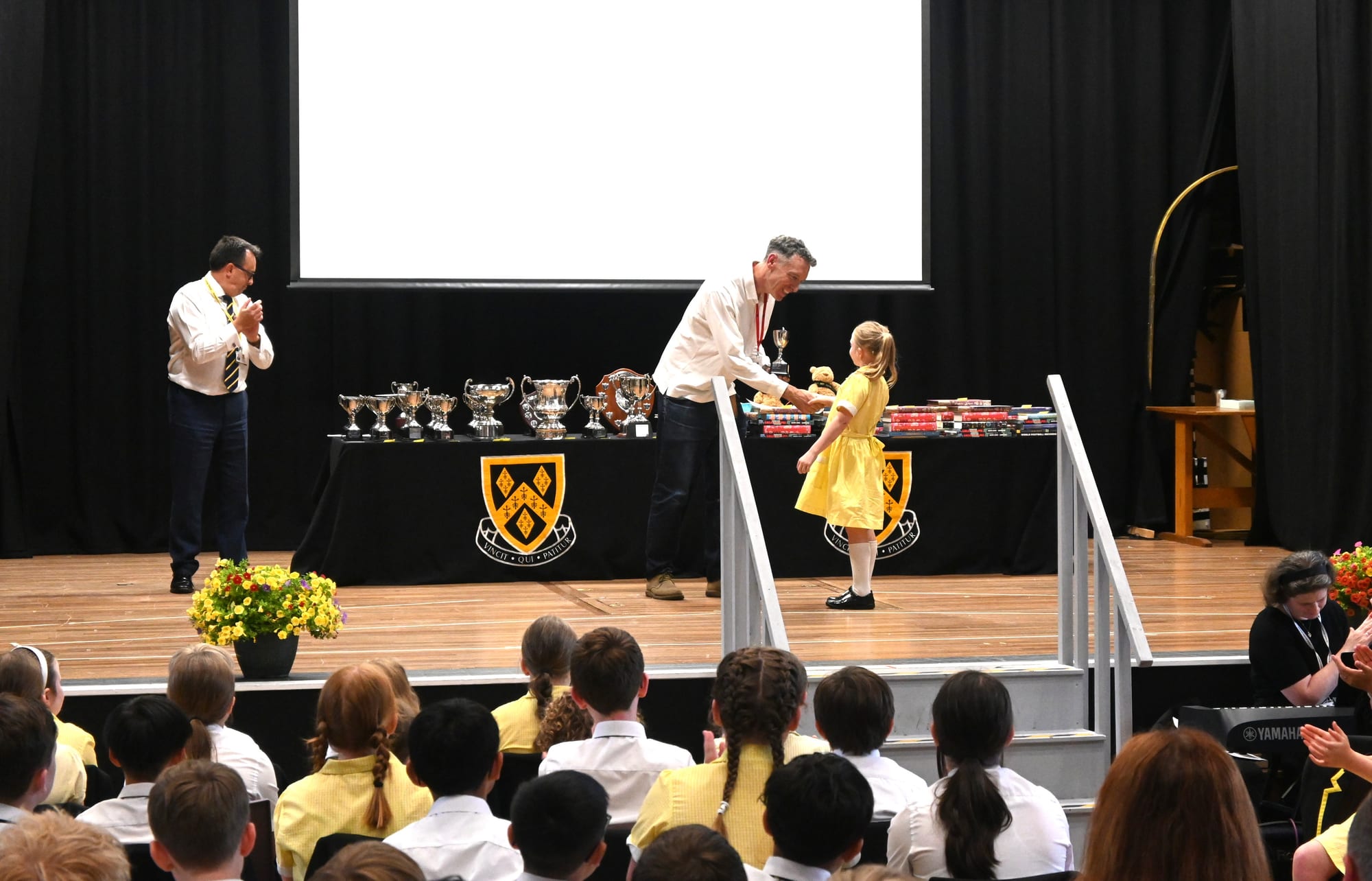 A pupil picking up her award from the guest of honour during the 2026 Junior School Prize Giving