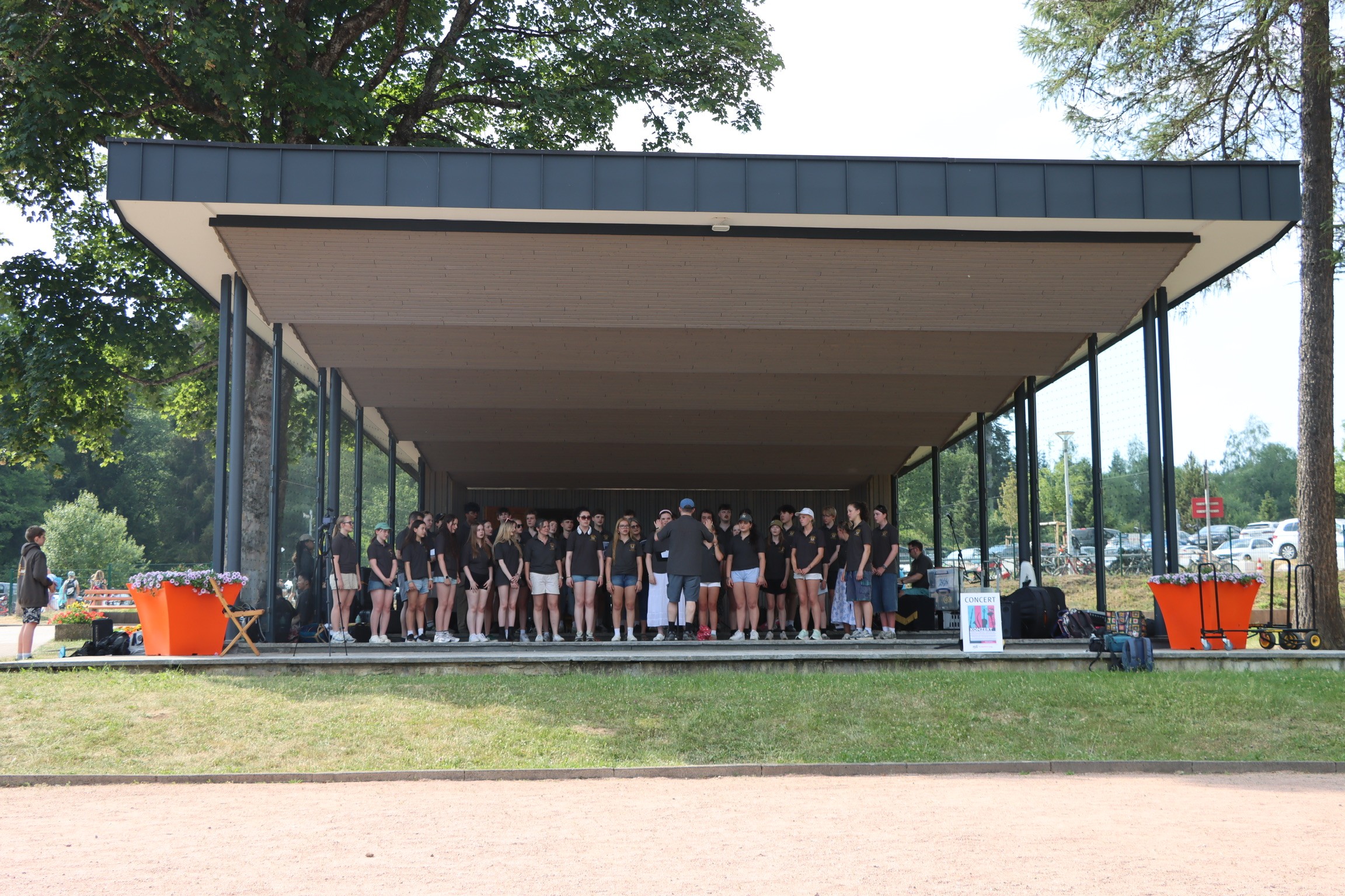 Singers performing outdoors at Titisee Lake Park during the 2026 music tour to the Black Forest, Germany